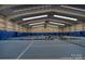 Indoor tennis court with blue playing surface and high ceilings, ideal for year-round play at 19622 River Falls Dr, Davidson, NC 28036