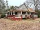 Home showcasing a covered porch with brick supports and mature trees in a wooded setting at 2412 Daves Dr, Shelby, NC 28152