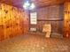 Living room with wood paneling, brick fireplace, and unique vintage light fixture at 2412 Daves Dr, Shelby, NC 28152
