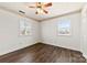 Bright bedroom with two windows, wood-look floors, ceiling fan and neutral wall paint at 305 Plantation Dr, Kings Mountain, NC 28086