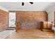 Charming living room with hardwood floors, brick wall, and seamless transition to a bright, modern kitchen at 305 Plantation Dr, Kings Mountain, NC 28086