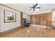 Living room with wood-burning stove, hardwood floors, brick accent wall, and natural light from multiple windows at 305 Plantation Dr, Kings Mountain, NC 28086