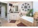 Bathroom featuring a soaking tub, double sink vanity, and decorative wall art at 3099 Trinity Church Rd, Concord, NC 28027