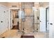 Large glass enclosed shower with built in shelves, storage, and decorative stone flooring at 3099 Trinity Church Rd, Concord, NC 28027