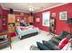 Cozy bedroom with red walls, a ceiling fan, and comfortable furnishings; designed with a unique personal touch at 3099 Trinity Church Rd, Concord, NC 28027