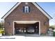 Spacious brick garage with an open door, vehicles, and storage, offering ample space for parking and projects at 3099 Trinity Church Rd, Concord, NC 28027