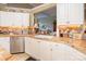 Detailed view of kitchen area features tiled countertops, white cabinets, and stainless steel dishwasher at 3099 Trinity Church Rd, Concord, NC 28027