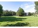 Expansive green yard with mature trees and a glimpse of the house at 3099 Trinity Church Rd, Concord, NC 28027