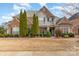 Charming two-story home featuring a stone and brick facade, landscaped yard, and balcony under a blue sky at 333 Willow Brook Dr, Matthews, NC 28105