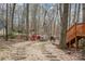 Private backyard oasis featuring a stone fire pit area with seating, surrounded by mature trees and natural landscaping at 3400 Thistle Bloom Ct, Charlotte, NC 28269