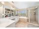 A spacious bathroom with a double sink vanity, jacuzzi bathtub, shower, and ample natural light at 3400 Thistle Bloom Ct, Charlotte, NC 28269