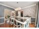 Elegant dining room with sophisticated lighting, patterned wallpaper, and hardwood floors at 3400 Thistle Bloom Ct, Charlotte, NC 28269