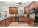 Kitchen featuring dark wood cabinets, black appliances, granite countertops, and plant accents at 3400 Thistle Bloom Ct, Charlotte, NC 28269