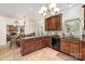 Kitchen featuring dark wood cabinets, black appliances, granite countertop and tile backsplash at 3400 Thistle Bloom Ct, Charlotte, NC 28269