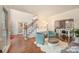 Open-concept living room features hardwood floors, a white piano, and comfortable seating at 3400 Thistle Bloom Ct, Charlotte, NC 28269