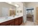 Bright bathroom features double vanity, large mirror, and glass shower with open doorway to bedroom at 4001 Perth Rd, Fort Mill, SC 29707