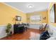 Sunny sitting room with a black piano, rocking chair, and hardwood flooring at 4001 Perth Rd, Fort Mill, SC 29707