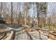 Stone path and fire pit surrounded by mature trees create a peaceful backyard retreat at 4828 Beth Ln, Harrisburg, NC 28075
