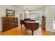 Elegant dining area featuring hardwood floors, wainscoting, and a baby grand piano under a decorative light fixture at 4828 Beth Ln, Harrisburg, NC 28075