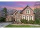 Elegant brick exterior home with a well-manicured lawn and mature trees, exhibiting classic architectural style at 4828 Beth Ln, Harrisburg, NC 28075