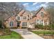 Beautiful red brick home featuring a long driveway, manicured lawn, and architectural details at 4828 Beth Ln, Harrisburg, NC 28075