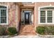 Elegant front entrance with brick steps, black door, and sidelight windows at 4828 Beth Ln, Harrisburg, NC 28075