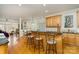 Open kitchen with granite counters, island with bar seating, wood cabinets, and view to living room at 4828 Beth Ln, Harrisburg, NC 28075
