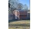 Backyard view of an outdoor shed with a metal door, providing additional storage space within the property at 516 W 7Th St, Kannapolis, NC 28081