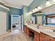 Bright bathroom boasts a spacious vanity with double sinks, warm lighting, and a decorative tile floor at 5405 Silver Creek Dr, Waxhaw, NC 28173