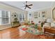 Cozy living room with a ceiling fan, many windows, and a bright, floral rug at 5405 Silver Creek Dr, Waxhaw, NC 28173