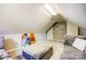 Attic bonus room featuring a comfortable sofa, surfboard decor, and a window for natural light at 7306 Timbercreek Ct, Denver, NC 28037