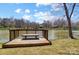Relaxing wood dock with a bench overlooking the calm lake and blue sky at 7306 Timbercreek Ct, Denver, NC 28037