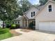 Exterior view of a two-story home with a brick facade, attached garage, and a well-maintained lawn at 7306 Timbercreek Ct, Denver, NC 28037