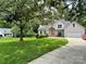 Charming home featuring a lush green lawn, mature trees, and an inviting driveway leading to the front entrance at 7306 Timbercreek Ct, Denver, NC 28037