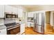 Bright kitchen features white cabinetry, stainless steel appliances, and hardwood floors at 7306 Timbercreek Ct, Denver, NC 28037
