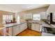 Bright kitchen with white cabinetry, stainless steel dishwasher, and hardwood floors at 7306 Timbercreek Ct, Denver, NC 28037