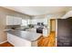 Bright kitchen features white cabinetry, stainless steel appliances, and hardwood floors at 7306 Timbercreek Ct, Denver, NC 28037