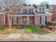 Charming red brick townhome featuring a cozy front porch with a bench swing at 9128 Kings Canyon Dr, Charlotte, NC 28210