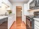 Bright kitchen featuring white cabinets, stainless steel appliances, and hardwood floors at 9128 Kings Canyon Dr, Charlotte, NC 28210