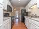 Galley kitchen with white cabinets, black appliances and hardwood floors at 9128 Kings Canyon Dr, Charlotte, NC 28210
