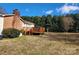 Great backyard space including a wooden deck, a brick chimney, and mature trees and shrubbery at 105 Brickyard Rd, Fort Mill, SC 29715