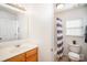 Bright bathroom with a vanity, toilet, and shower/tub combo with a striped curtain at 10530 Stoneacre Ct, Pineville, NC 28134