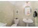 Cozy half bathroom featuring a pedestal sink, decorative mirror, and soft green wall decor at 10530 Stoneacre Ct, Pineville, NC 28134