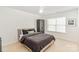 Bright, minimalist bedroom with a comfortable bed, neutral colors, and a ceiling fan at 10530 Stoneacre Ct, Pineville, NC 28134