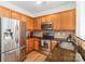 Well-equipped kitchen featuring stainless steel appliances, granite countertops, and wood cabinetry at 10530 Stoneacre Ct, Pineville, NC 28134