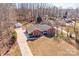 Aerial view of a brick home with a long driveway, surrounded by trees, and detached garage at 11 Heritage Ln, Shelby, NC 28150
