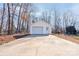 Detached garage with a white door, surrounded by mature trees, sits at the end of a long driveway at 11 Heritage Ln, Shelby, NC 28150
