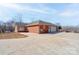 A brick home with a large driveway, showing the side and garage entrance with mature trees in the background at 11 Heritage Ln, Shelby, NC 28150