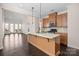 Open kitchen with wooden cabinets, granite countertops, a kitchen island, stainless steel appliances, and dark wood floors at 1114 Roderick Dr, Fort Mill, SC 29708