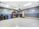 Spacious garage featuring epoxy flooring, garage door opener, added storage, and neon sign at 118 Isleworth Ave, Mooresville, NC 28117